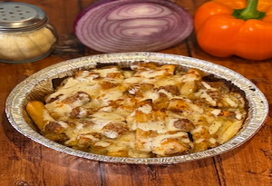 Genos Giant Slice pizza in foil pan with cheese, chicken, and veggies, served with onions and bell pepper on wooden table