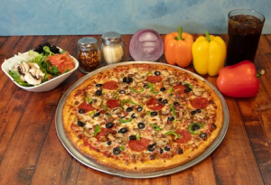 image005 Genos Giant Slice pizza with pepperoni, olives, and peppers on wooden table beside salad and drinks