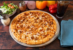 image007 Genos Giant Slice pizza on metal tray with side salad, peppers, and drink on wooden table